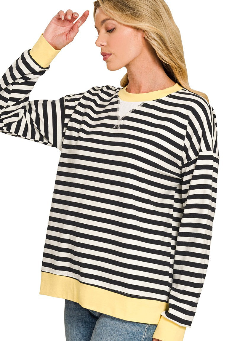 woman wearing a black and white striped pullover top with yellow trim