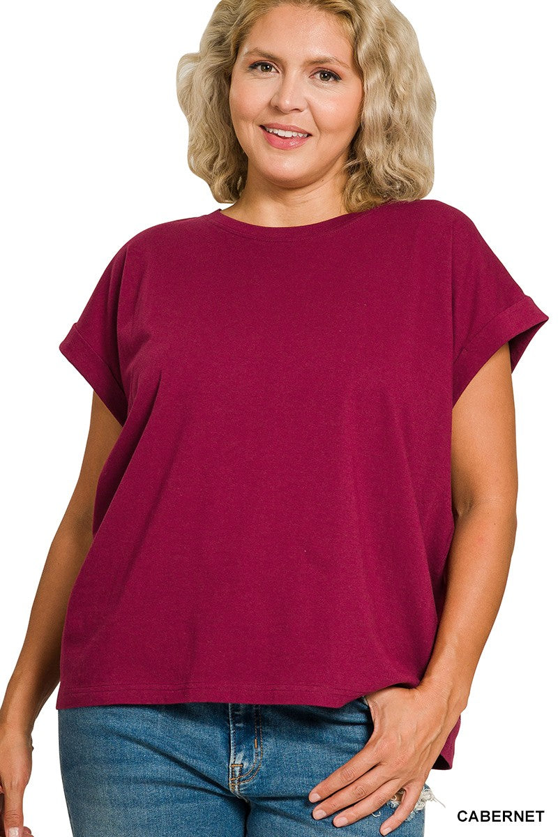 Woman wearing a cabernet folded sleeve top and blue jeans on a white background