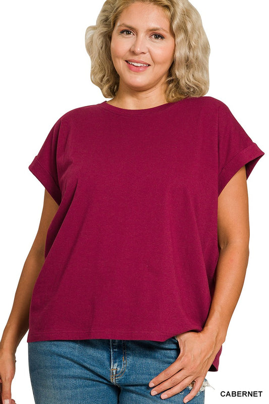 Woman wearing a cabernet folded sleeve top and blue jeans on a white background
