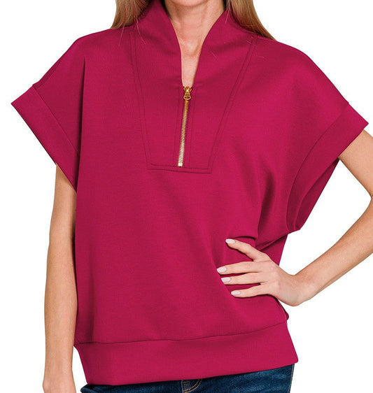 Woman wearing a burgundy short-sleeve top with a zipper on a white background