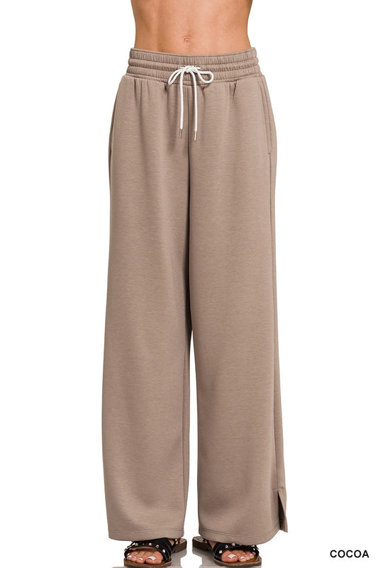 Beige wide-leg pants with a drawstring waist on a white background