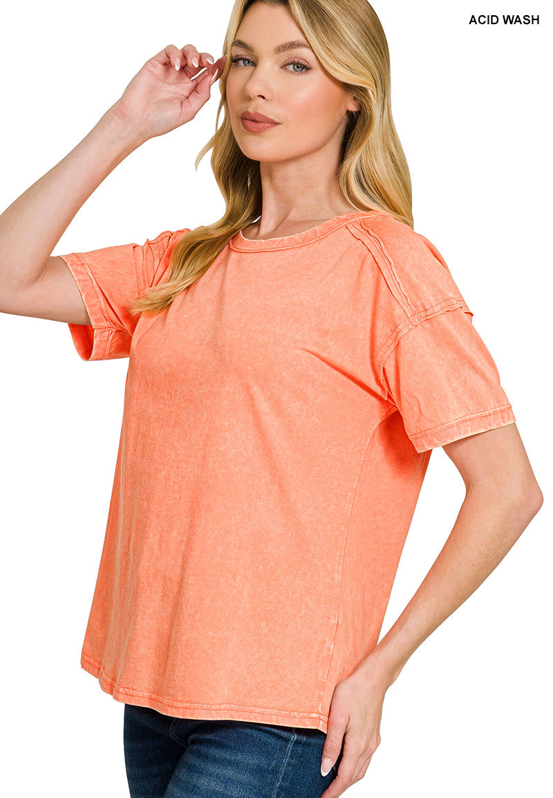 Woman wearing a coral acid wash t-shirt on a white background