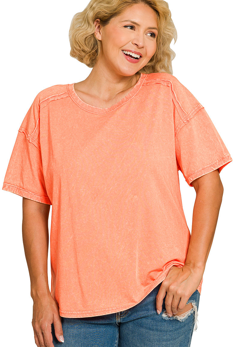 Woman wearing a coral t-shirt and blue jeans on a white background