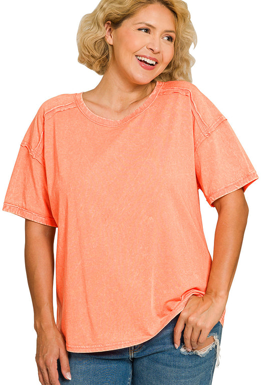 Woman wearing a coral t-shirt and blue jeans on a white background