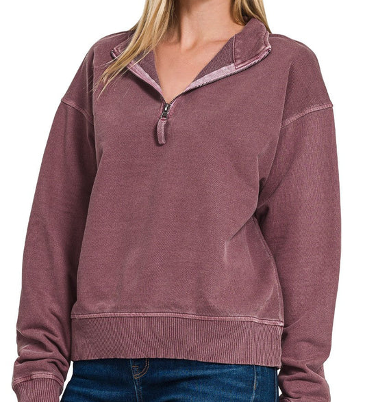 Woman wearing an eggplant-colored pullover with a white background