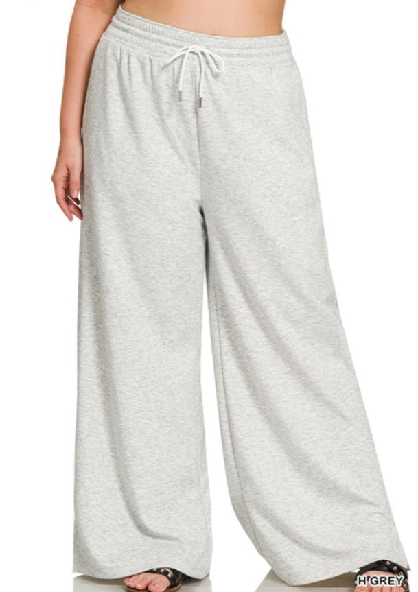 Gray sweatpants worn by a person on a white background