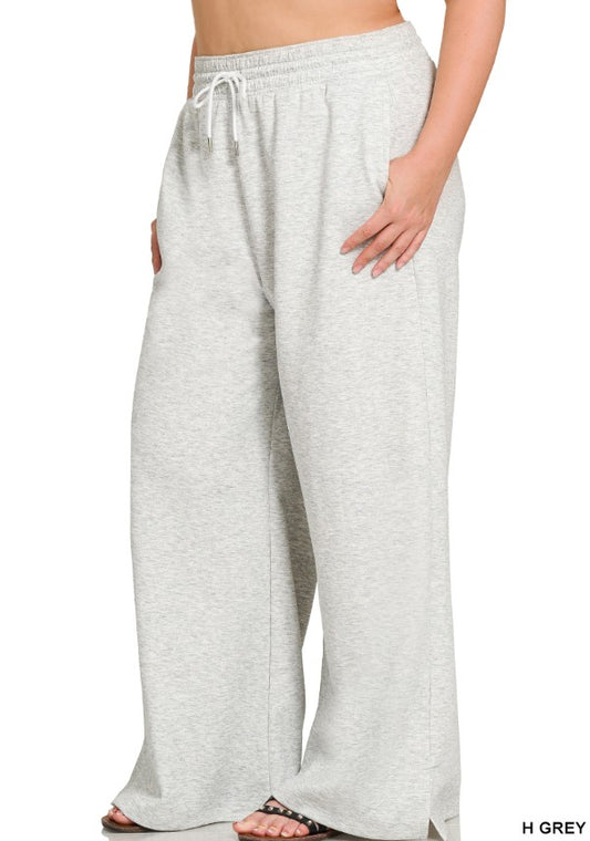 Gray sweatpants worn by a person on a white background