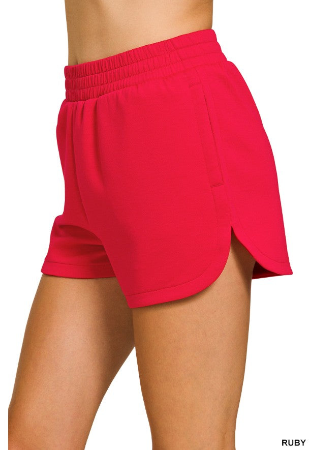 Red shorts worn by a person on a white background