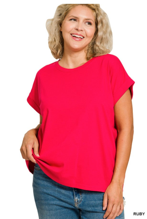 Woman wearing a bright red top and blue jeans on a white background