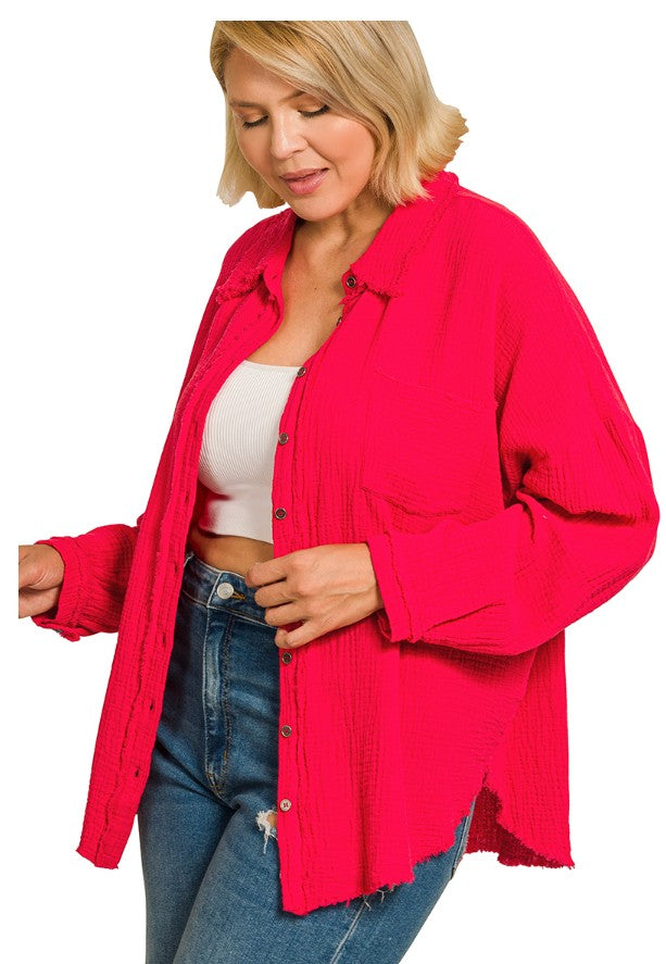 Woman wearing a bright pink jacket over a white top and blue jeans on a white background