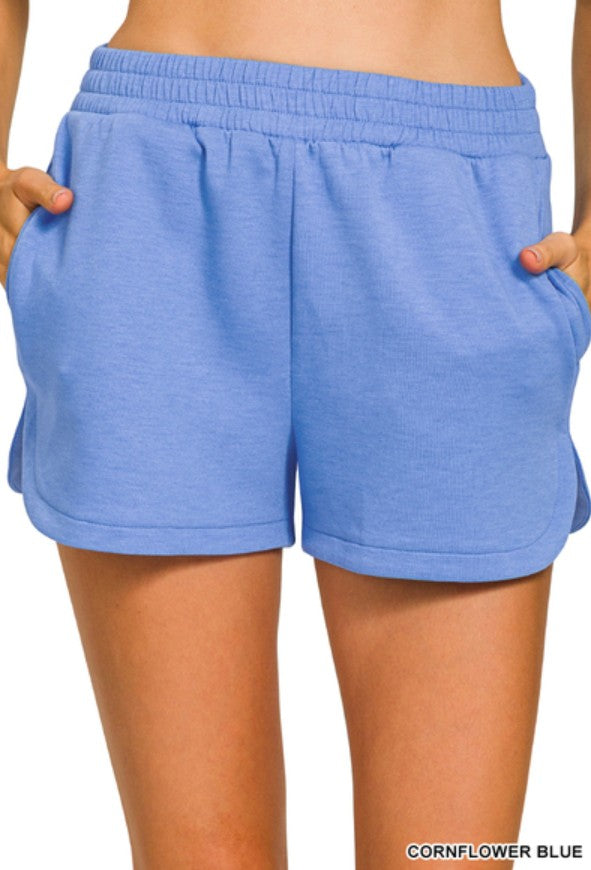 Blue shorts being worn on a white background