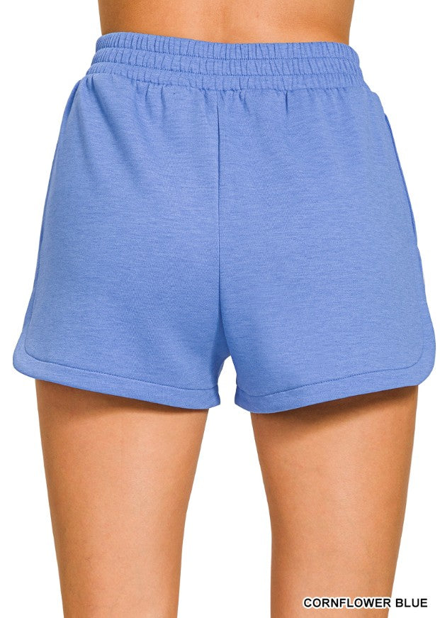 Blue shorts worn by a person on a white background