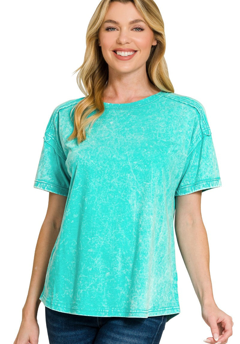 Woman wearing a turquoise exposed seam top on a white background