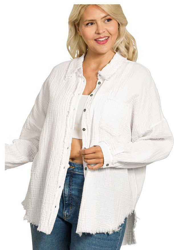Woman wearing a white oversized shirt with a plain background