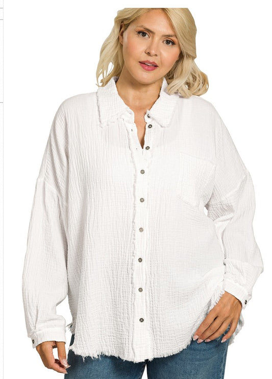 Woman wearing a white button-up shirt with a subtle pattern on a white background